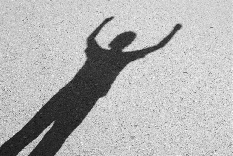 A persons shadow with arms raised